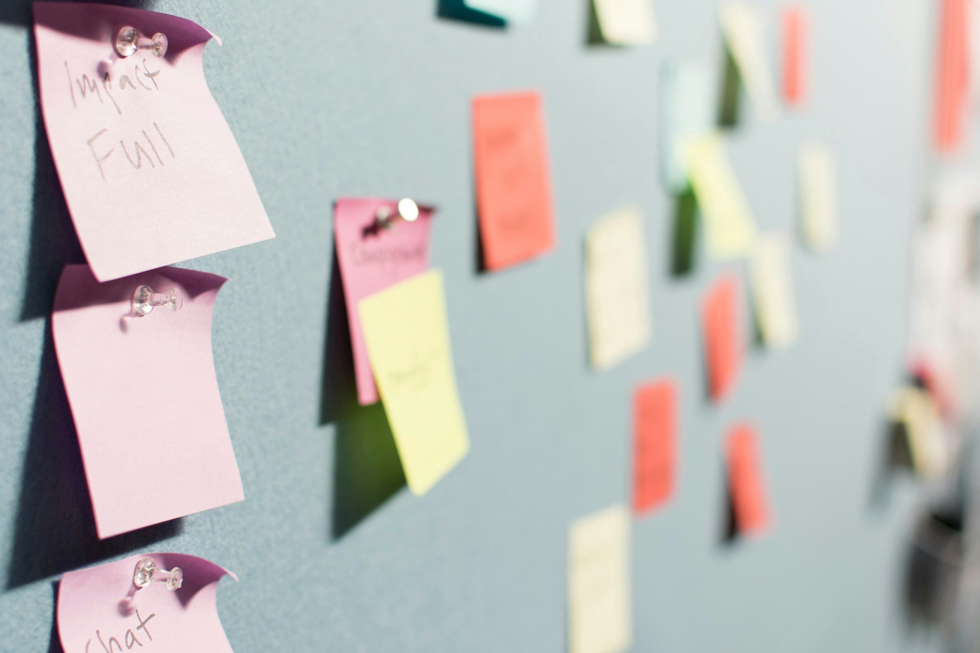 Des notes colorées épinglées sur un mur, pendant un atelier