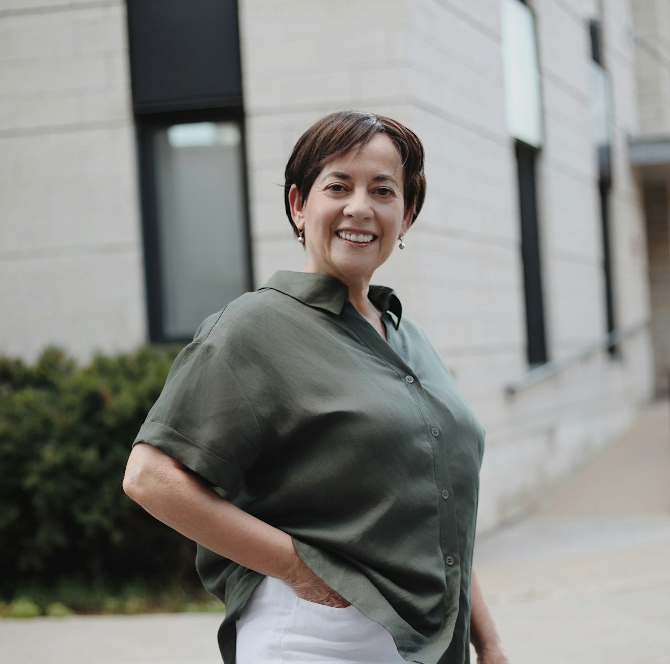 Inès Vautrin, consultante en organisation, souriante, devant un immeuble lyonnais