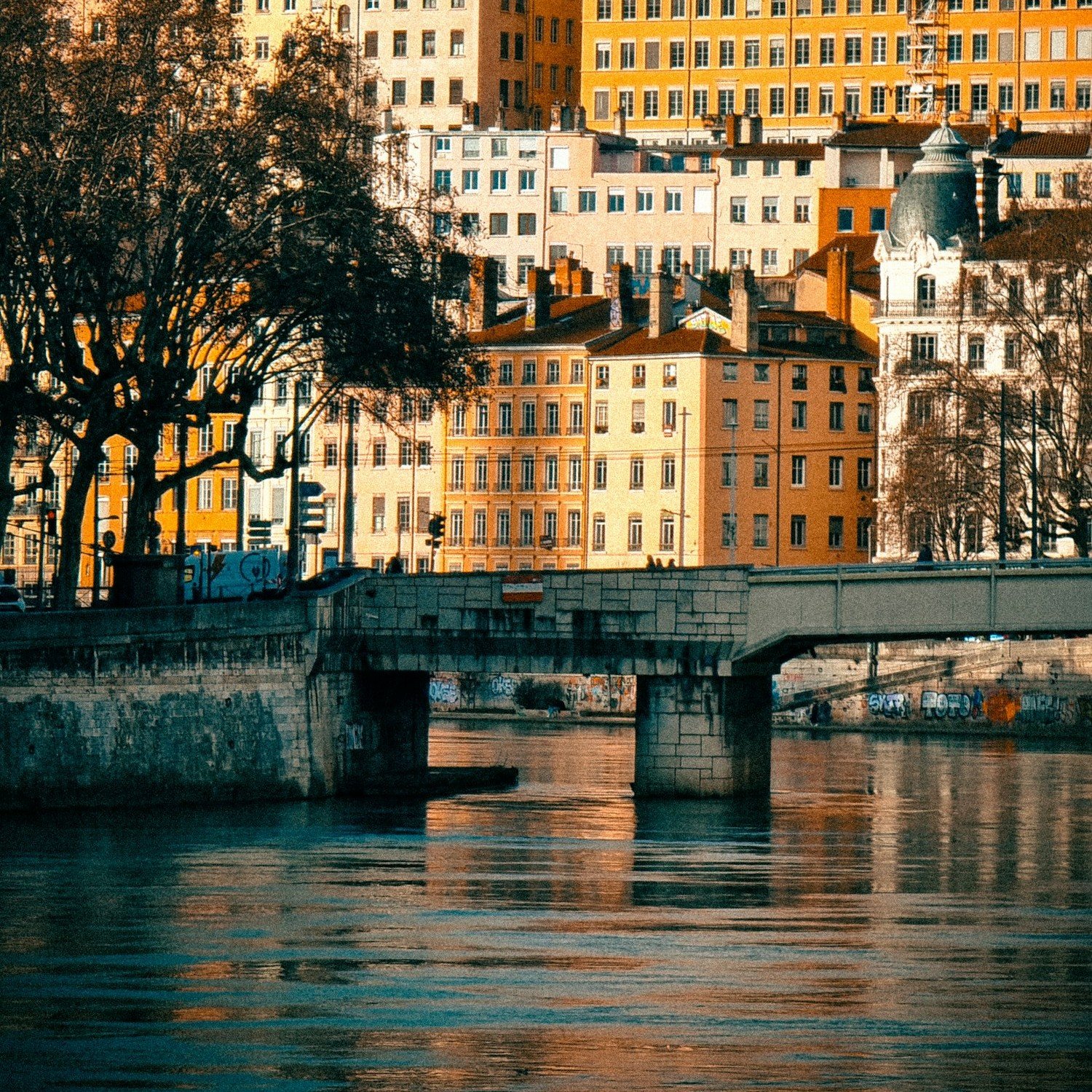 Les immeubles ocre des pentes de la Croix-Rousse et un pont sur la Saône